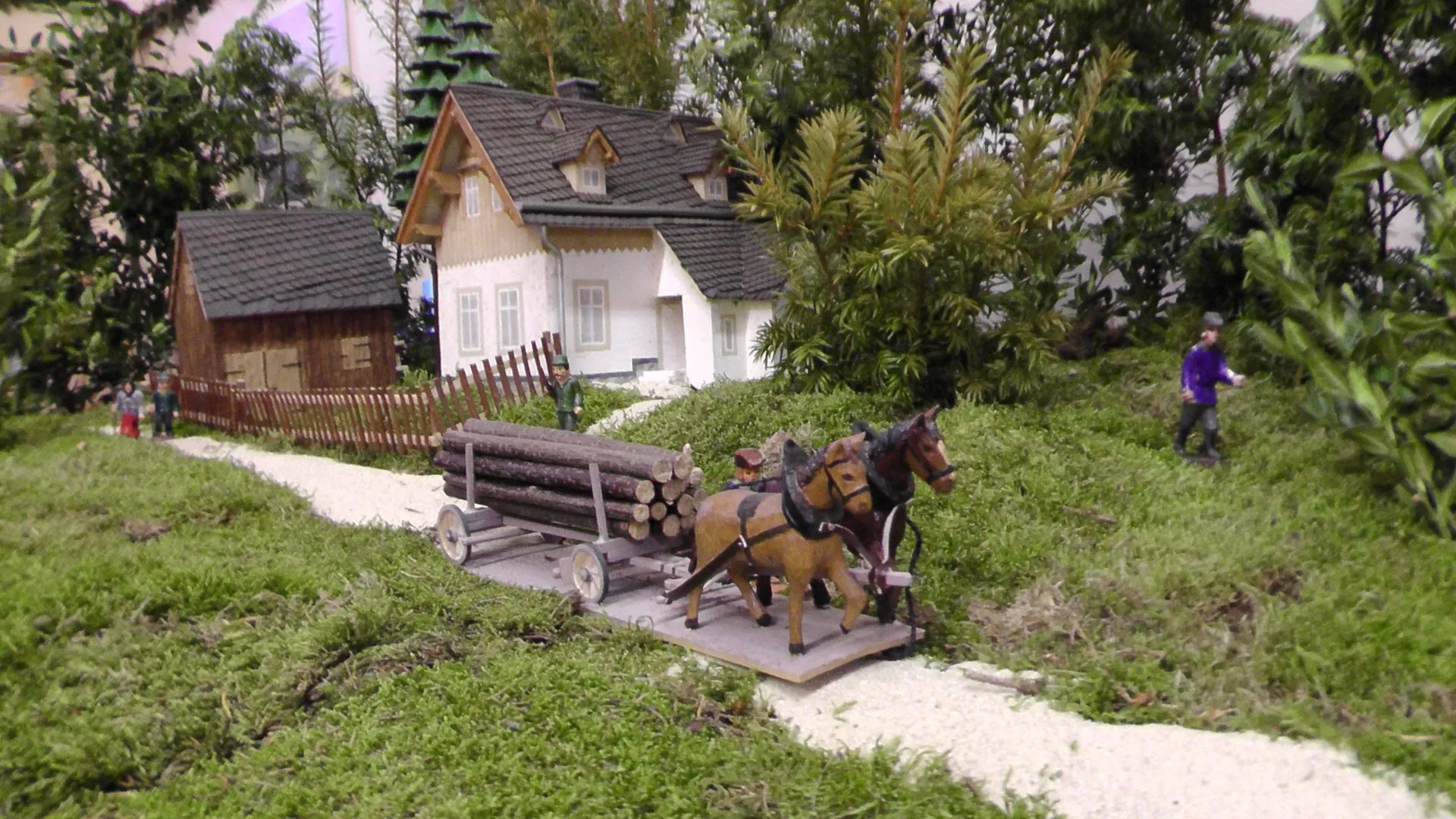 Modell des Bornwalddorfes: ein Pferdefuhrwerk mit Holzstämmen vor Fachwerkhäusern im Grünen